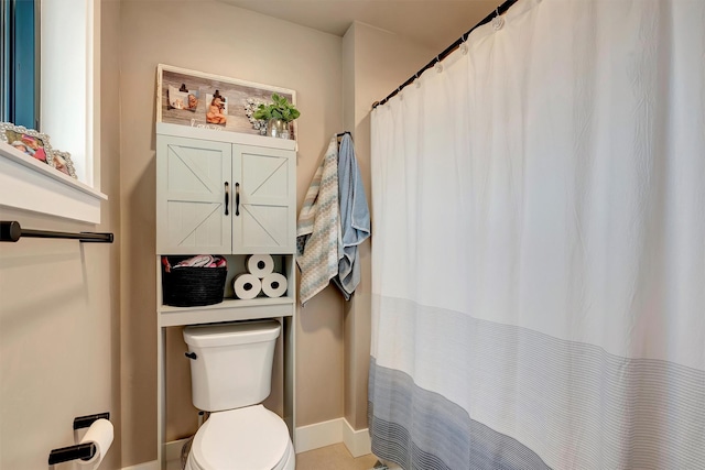 full bath with baseboards, toilet, and curtained shower