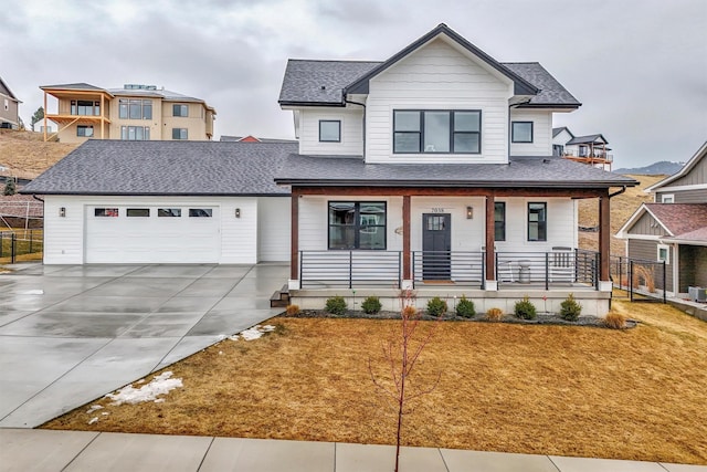 modern inspired farmhouse featuring a porch, an attached garage, a shingled roof, and driveway