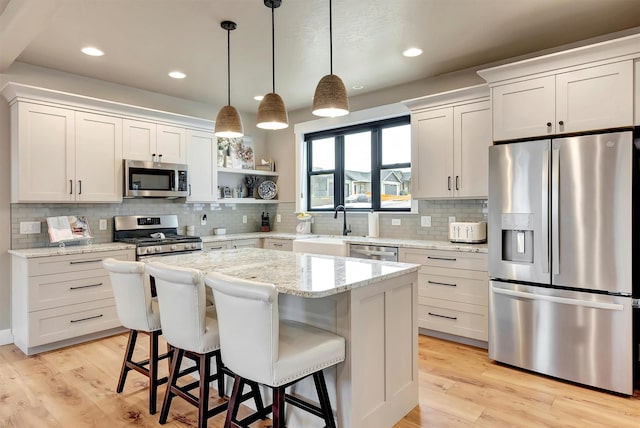kitchen with open shelves, backsplash, a breakfast bar, decorative light fixtures, and appliances with stainless steel finishes