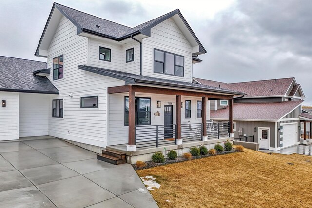 7038 Max Dr, Missoula, MT 59803 - view of front of home featuring covered porch, a shingled roof, and a front yard