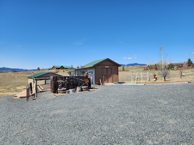 view of yard featuring an outdoor structure, a mountain view, and a shed