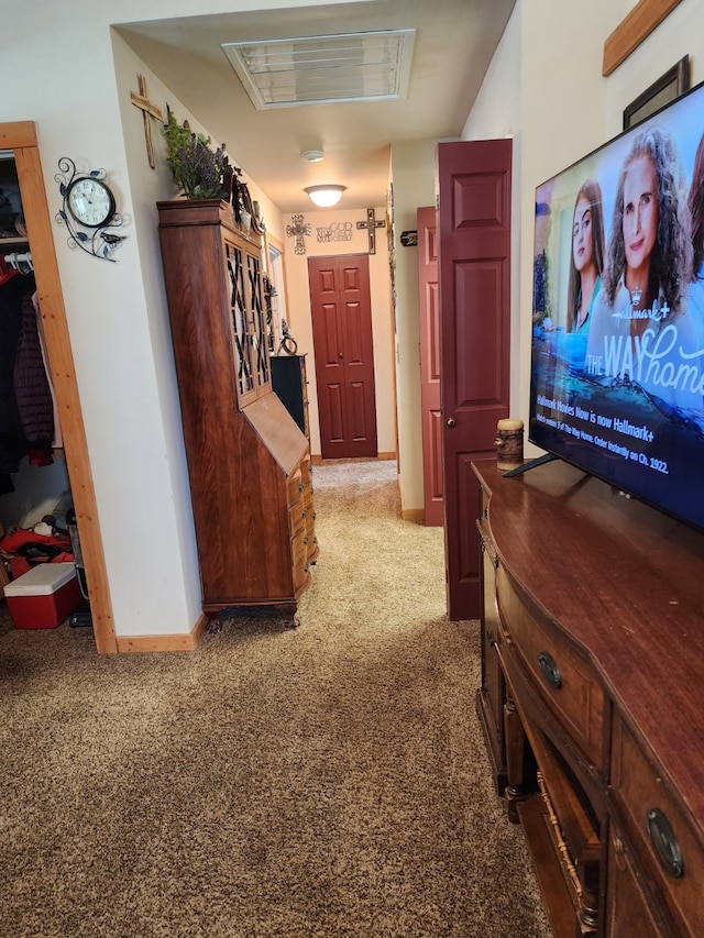 corridor featuring baseboards, visible vents, and light carpet