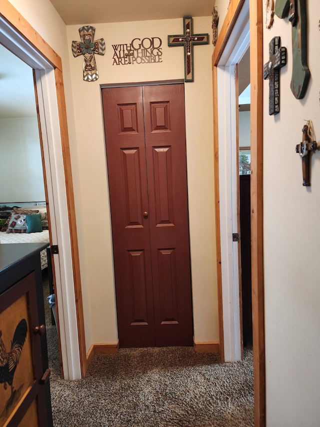 corridor featuring baseboards and carpet
