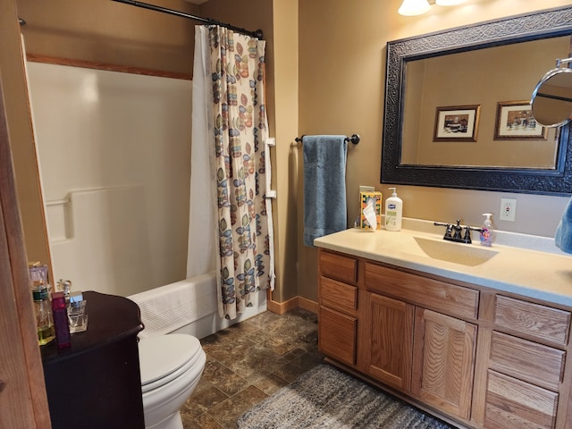 bathroom featuring toilet, stone finish flooring, shower / bath combo with shower curtain, and vanity