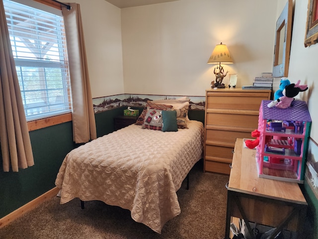 bedroom featuring baseboards and dark carpet