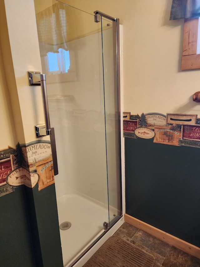 bathroom featuring stone finish floor and a stall shower