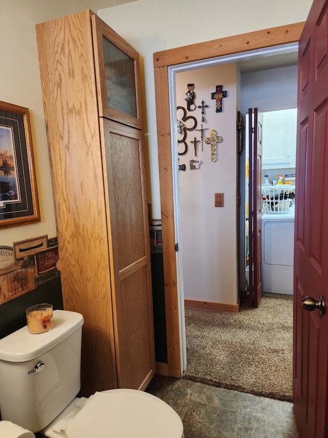 bathroom with washer / dryer, baseboards, and toilet