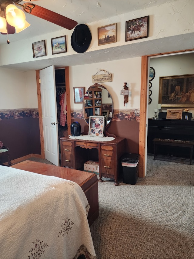 bedroom featuring carpet flooring, ceiling fan, wainscoting, and a closet