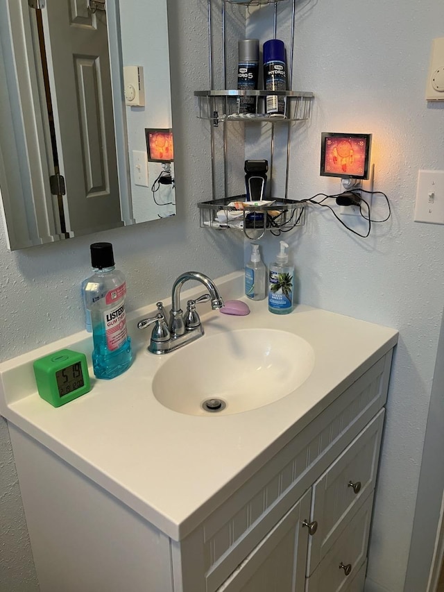 bathroom featuring a textured wall and vanity