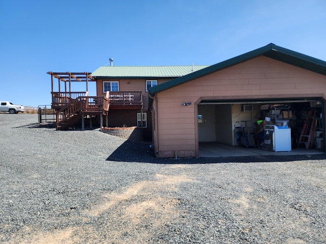 back of property with metal roof, stairway, and a deck