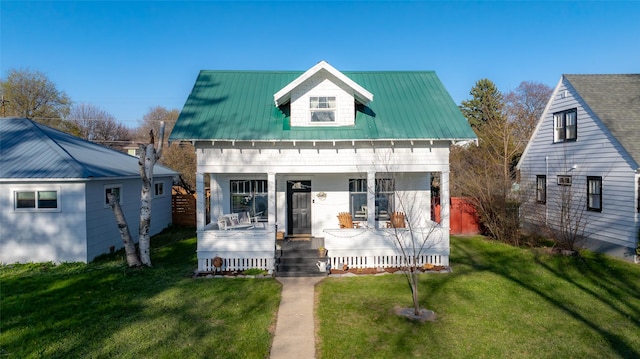 bungalow-style house featuring a porch, a front lawn, and metal roof