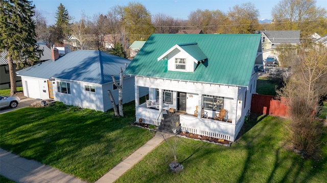 view of front facade featuring fence, a front yard, and metal roof