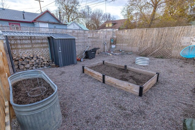 view of yard with an outdoor structure, a garden, a shed, and a fenced backyard