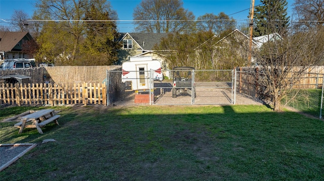 view of yard featuring a storage shed, a fenced backyard, and a gate