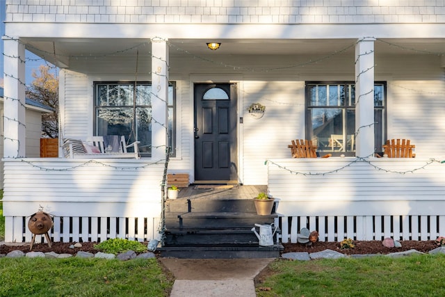 view of exterior entry with a porch