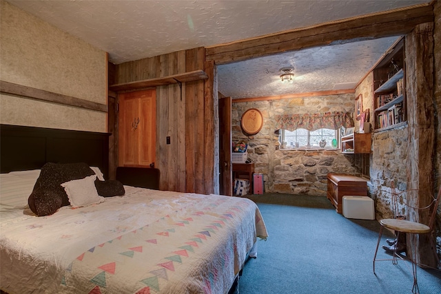 carpeted bedroom with ceiling fan and beamed ceiling