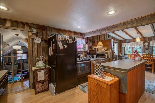 kitchen featuring dark countertops, light wood-style flooring, open floor plan, and lofted ceiling with beams