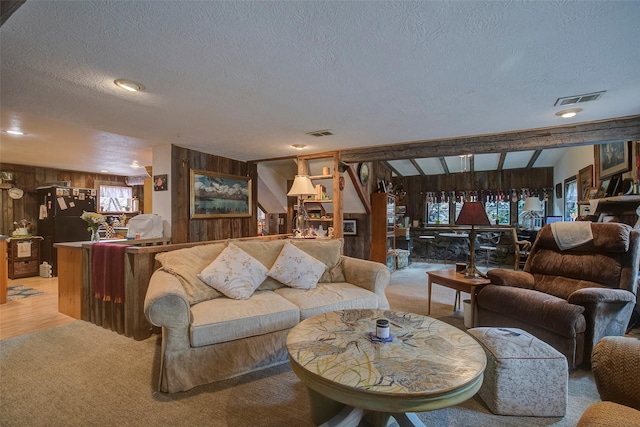 carpeted home office featuring lofted ceiling with beams, wooden walls, and ceiling fan