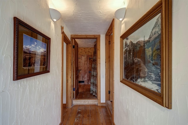 interior space featuring vaulted ceiling, a healthy amount of sunlight, baseboards, and hardwood / wood-style floors