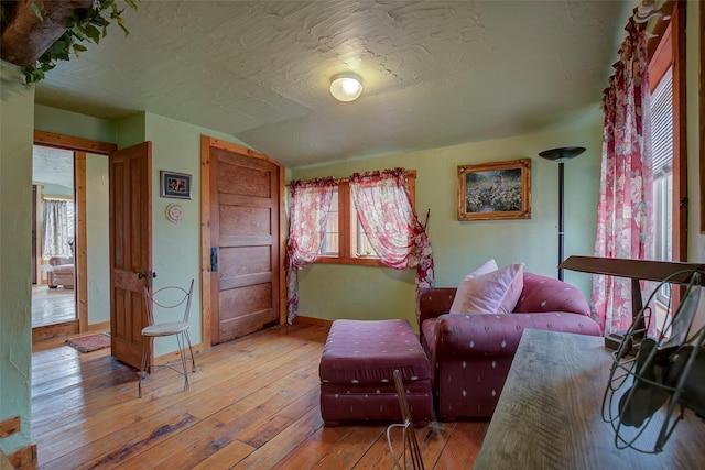 bedroom featuring beamed ceiling, hardwood / wood-style flooring, and baseboards