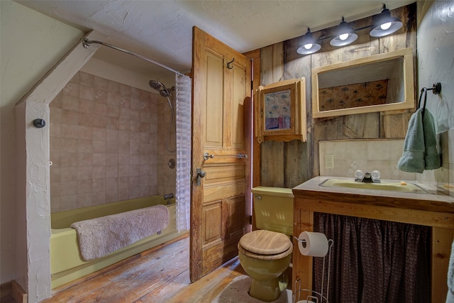 bedroom featuring hardwood / wood-style flooring, lofted ceiling, multiple windows, and baseboards