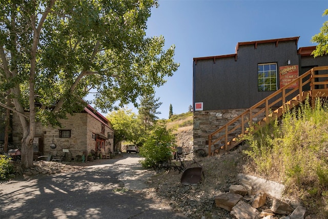 view of side of property with stone siding and stairs
