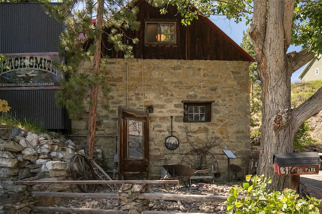 view of side of property with stone siding and stairs