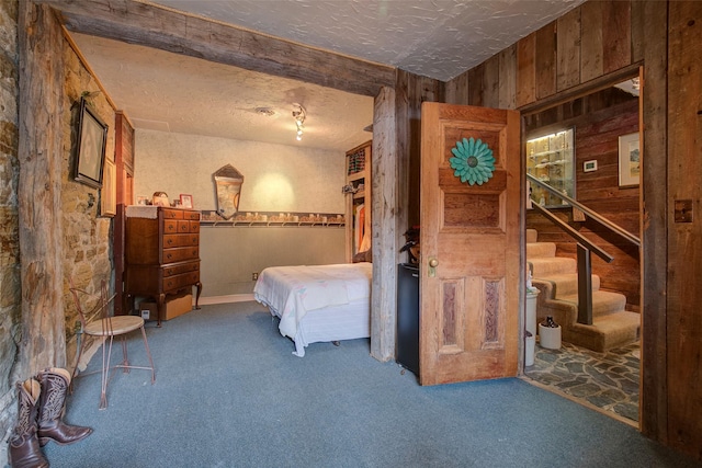 carpeted bedroom featuring a ceiling fan, wood walls, and crown molding