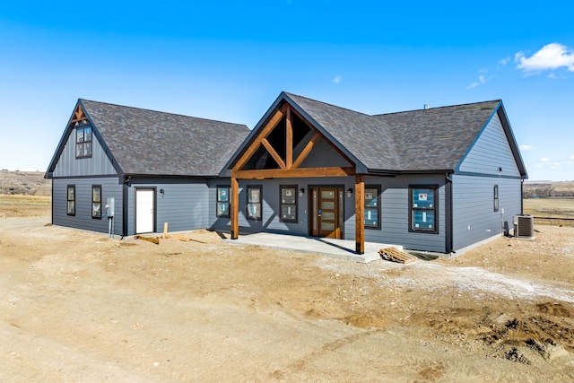 modern inspired farmhouse featuring a porch, central AC, and roof with shingles