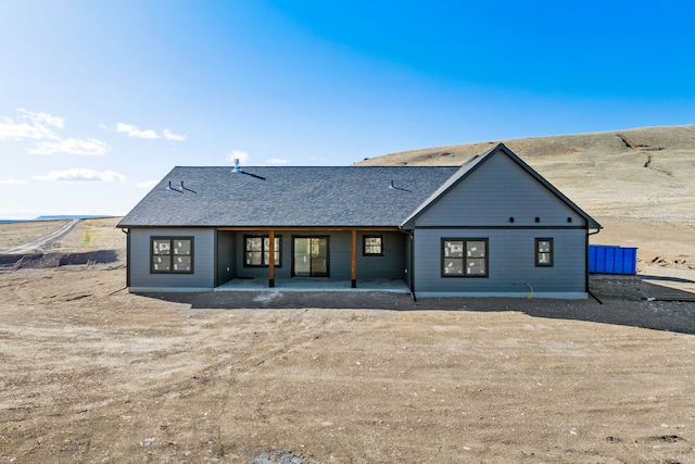 rear view of house featuring roof with shingles