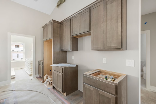 kitchen with lofted ceiling and dark brown cabinetry