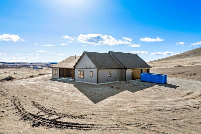 rear view of property with roof with shingles