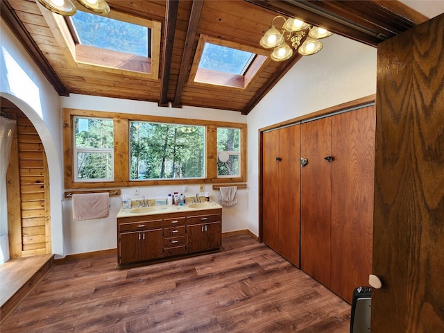full bathroom with wood ceiling, lofted ceiling with skylight, wood finished floors, and a sink