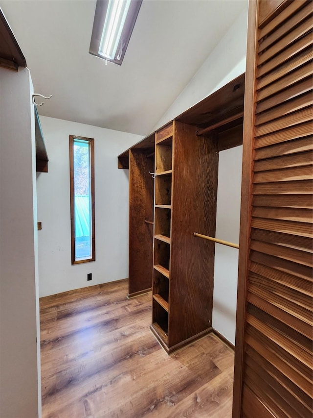 spacious closet featuring vaulted ceiling and wood finished floors