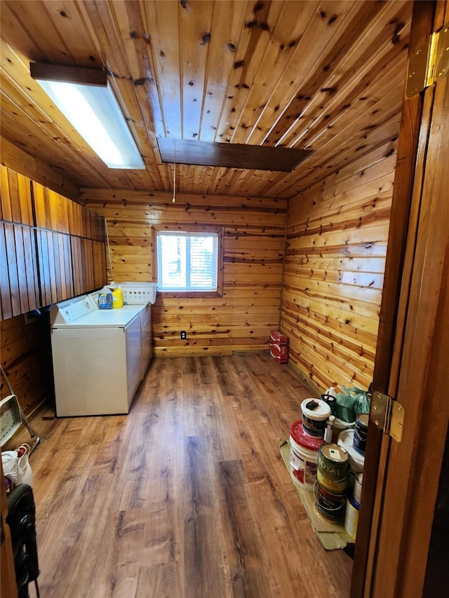 laundry room featuring washing machine and clothes dryer, wood finished floors, wood ceiling, wood walls, and laundry area