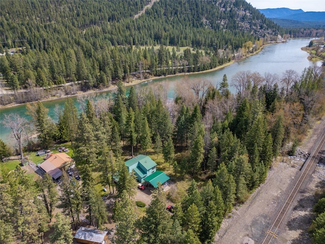 birds eye view of property featuring a wooded view and a water and mountain view