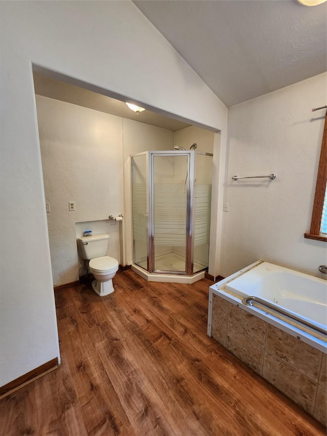 full bath with toilet, vaulted ceiling, wood finished floors, a shower stall, and a garden tub