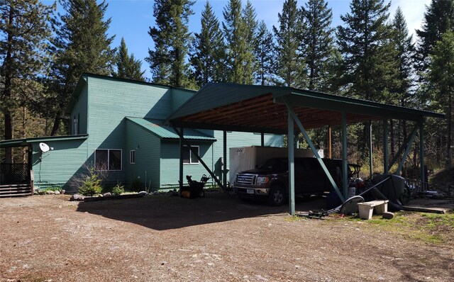 view of parking with a carport and dirt driveway
