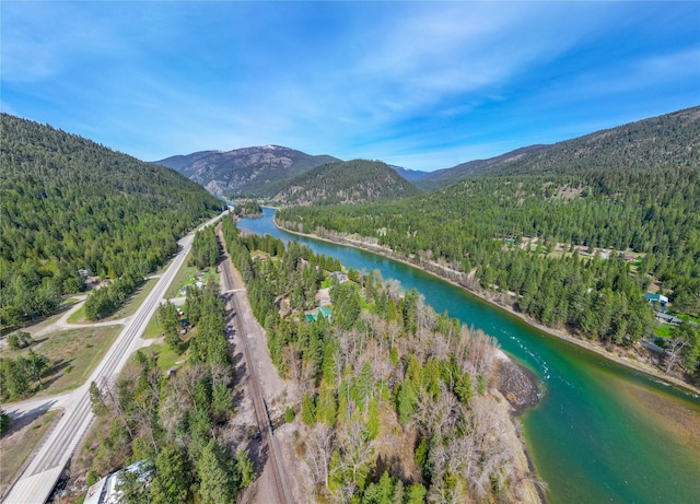 bird's eye view featuring a wooded view and a water and mountain view