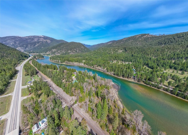 birds eye view of property with a water and mountain view and a forest view