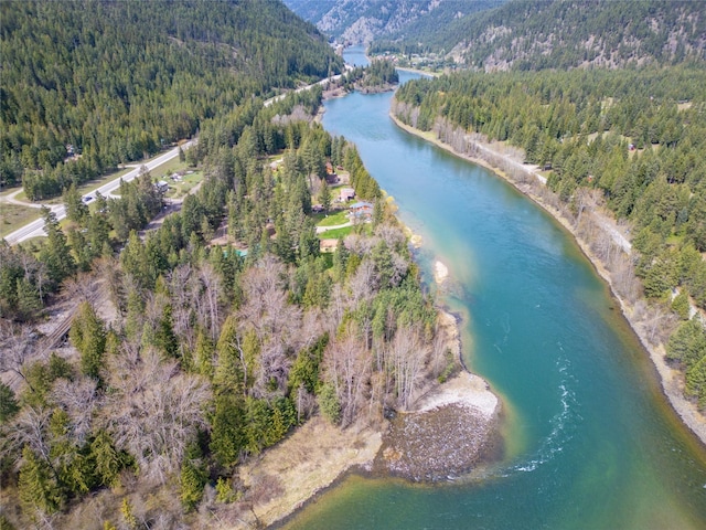 aerial view featuring a water and mountain view and a forest view