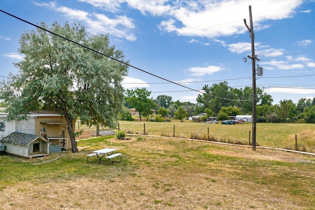 view of yard featuring an outdoor structure, fence, and a storage shed