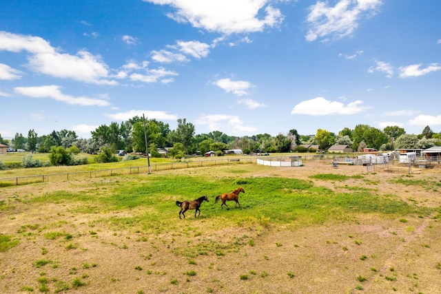 view of yard with fence and a rural view