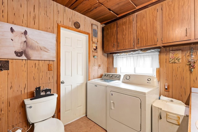 laundry room featuring light tile patterned flooring, washing machine and dryer, wood walls, cabinet space, and wooden ceiling