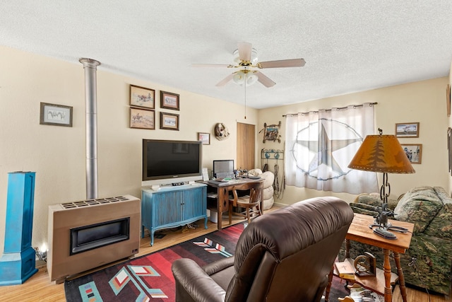 living area with wood finished floors, a textured ceiling, and ceiling fan