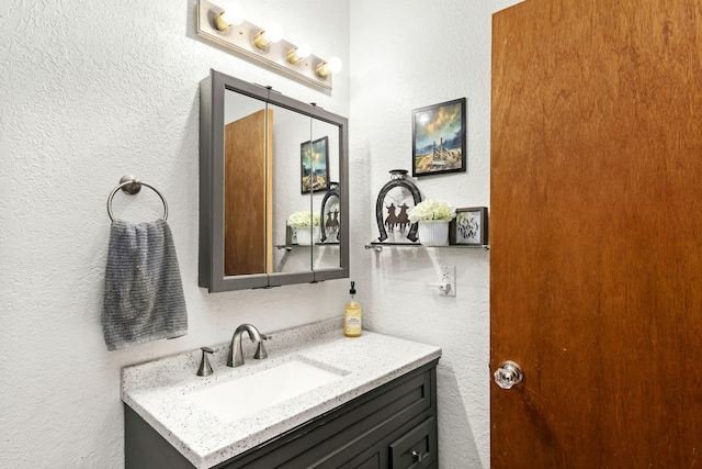 bathroom featuring a textured wall and vanity