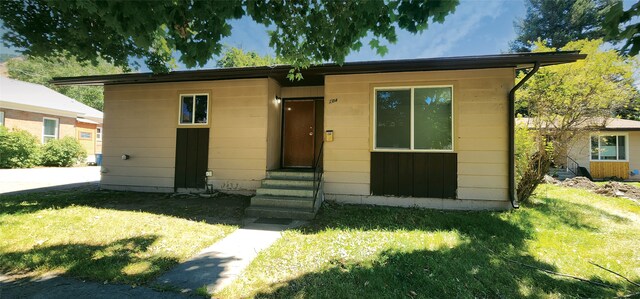 bungalow-style house featuring entry steps and a front lawn