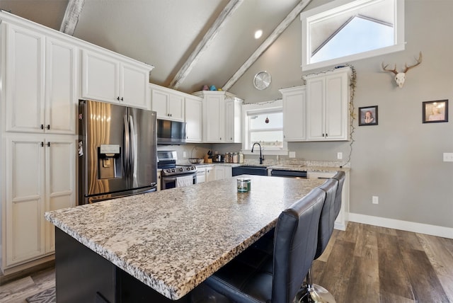 kitchen with a center island, dark wood-style floors, stainless steel appliances, and a sink