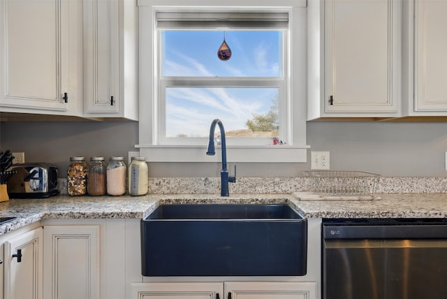kitchen with a wealth of natural light, dishwasher, a sink, and white cabinetry
