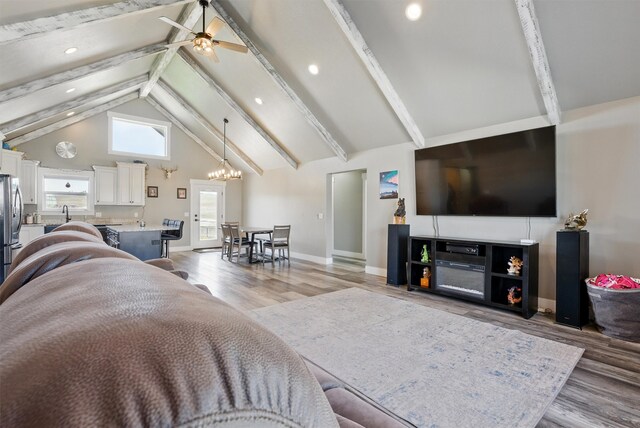 living room featuring high vaulted ceiling, a ceiling fan, beam ceiling, and light wood-type flooring